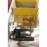 Toys: Iron stove enamel child's "Bing" hand driven sewing machine with box.