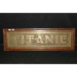 R.M.S. TITANIC: Post-war stylised brass sign Titanic on oak backing board. 33ins.