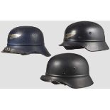 Drei Luftschutzhelme Ein Helm vom Gladiatortyp mit dunkelblau lackierter, zusammengesetzter