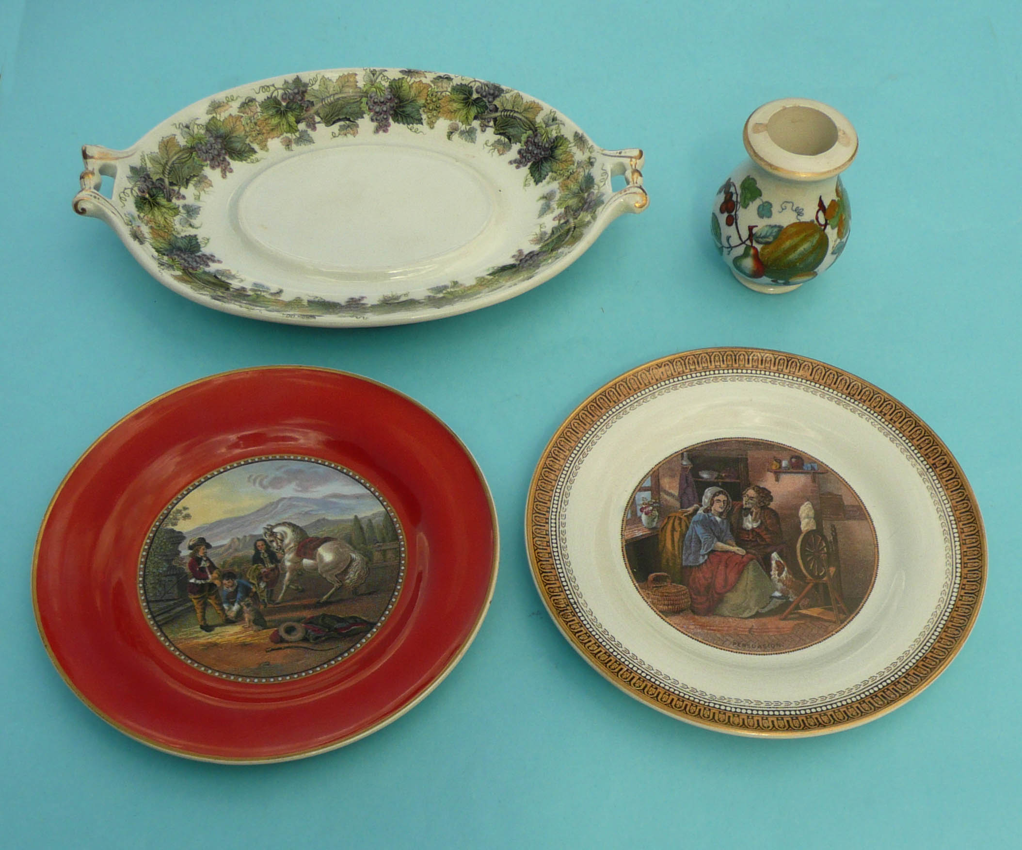 Two side plates, an oval stand with fruiting vine border and a small baluster jar with fruits and