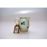 AN 18TH CENTURY BLUE AND WHITE CREAM JUG OF REEDED FORM, PAINTED WITH FLOWERS,