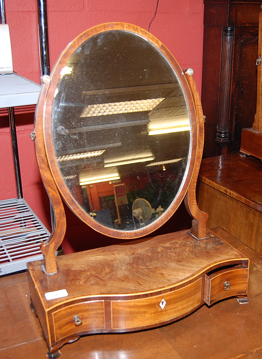 A GEORGE II MAHOGANY SERPENTINE DRESSING MIRROR WITH OVAL FRAME