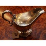 A HEAVY SILVER SAUCEBOAT WITH DOUBLE SCROLLED HANDLE,