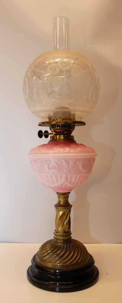 A BRASS OIL LAMP WITH DUPLEX BURNER AND PINK GLASS MOULDED FONT