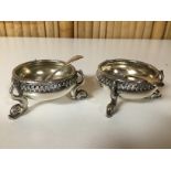 A PAIR OF CIRCULAR SILVER SALTS ON TRIPOD DOLPHIN SUPPORTS,