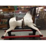 A VICTORIAN PAINTED ROCKING HORSE ON TRESTLE STAND WITH HORSE HAIR MANE AND TAIL AND A LEATHER