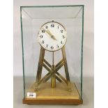 A REPRODUCTION BRASS SKELETON MYSTERY CLOCK UNDER SQUARED GLASS DOME,