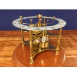 A REPRODUCTION BRASS PLANET CLOCK UNDER GLASS DOME