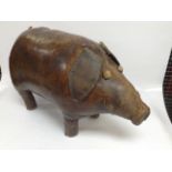 AN UNUSUAL WELL LOVED LEATHER COVERED PIG STOOL,