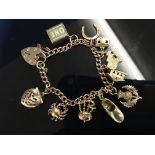 9CT. GOLD CHARM BRACELET WITH 10 CHARMS MOSTLY HALLMARKED (APPROX.