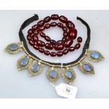 A red amber bead necklace, of graduated oval beads, together with a North African fringe necklace