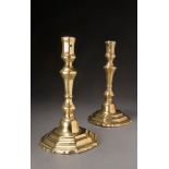 A pair of early 18th century brass candlesticks, with octagonal section stems, 'drip pan less'