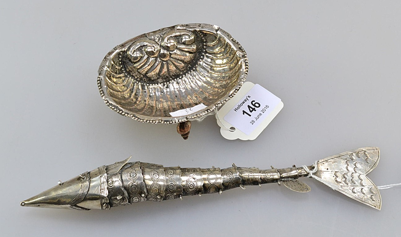 An unmarked continental silver salt, modelled as an open scallop shell standing proudly on four