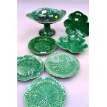A large collection of mostly late 19th century green glazed leaf moulded dessert plates, comports