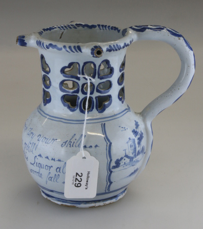 An 18th century Delft puzzle jug, probably Liverpool, painted underglaze in blue with landscapes and