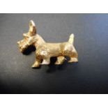 A 9ct gold brooch in the form of a West Highland terrier with red stone eye - L3.