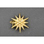 An 18ct gold star brooch/pendant set with central diamond and seed pearls, with safety chain,