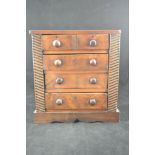 An early 19th Century miniature elm and fruitwood chest, four drawers with turned handles - H33cm,