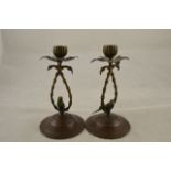 A pair of cold painted bronze candlesticks formed as budgerigars underneath palm trees,