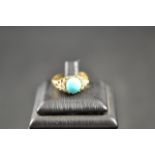 An 18ct gold ring with central cabochon turquoise and diamond set shoulders - size N. CONDITION