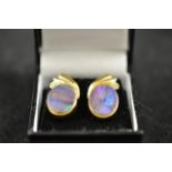 A pair of 18ct gold stud earrings set with oval opals and diamond set stylised feather surmount -