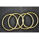 Four Thai yellow metal bangles of traditional stylized bamboo design (likely to be high purity gold)