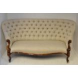 A Victorian walnut framed settee upholstered in buttoned fabric, scroll arms and cabriole legs -