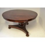 An early 19th century mahogany circular tilt top dining table, shaped hexagonal column, triform base