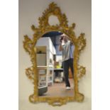 A 20th century Georgian reproduction giltwood framed wall mirror of floral and scroll design -