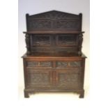 A carved oak sideboard, four panels to back carved with mythical beasts, two drawers and cupboard