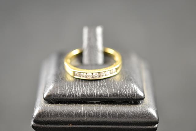 An 18ct gold ring with seven channel set diamonds - size O 1/2. CONDITION REPORT good condition