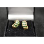 A pair of 14ct gold drop earrings set with alternating bands of emeralds and diamonds - approx.