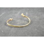 A 9ct gold torque bangle set with two diamonds - approx gross weight 16.7g CONDITION REPORT good