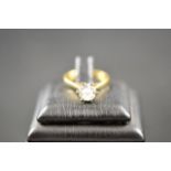 An 18k gold ring set with a solitaire diamond, size L