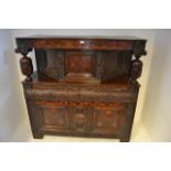 A mid 17th century court cupboard, bog oak inlay, canted corners to top section with central