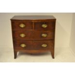 An early 19th century inlaid mahogany bow fronted chest, two short and two long drawers, oval