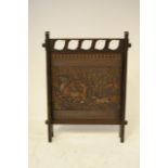 A Liberty & Co. oak framed Arts & Crafts style fire screen with Leatho embossed leather insert -