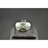 A 14ct white gold ring set with diamonds and emeralds in Art Deco style design - size N. CONDITION