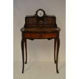 A late 19th century continental bureau de dame, inset single train clock with painted enamel dial,