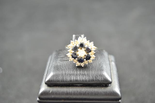 An 18ct white gold ring with diamonds and sapphires in floral setting - size K.