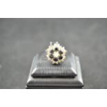 An 18ct white gold ring with diamonds and sapphires in floral setting - size K.