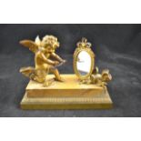 After Jean Antoine Houdon (1741-1828) - a gilt metal figure of cupid looking into a mirror, on