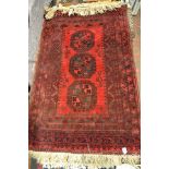 A Middle Eastern red ground rug, three octagons to centre, multiple border - 160x102cm CONDITION