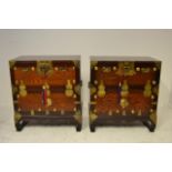 A pair of 20th Century Korean elm bedside cabinets with brass mounts to the drop down cupboard -