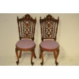 A pair of mid Victorian carved walnut children's chairs, scroll crest rail, pierced back, shell