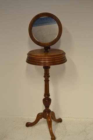 A late 19th century walnut shaving stand, circular mirror above two compartments, melon turned