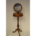 A late 19th century walnut shaving stand, circular mirror above two compartments, melon turned