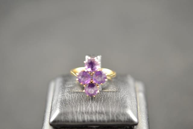 A 9ct gold ring with four claw set round amethysts - size L, approx gross weight 2.9g. CONDITION