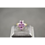 A 9ct gold ring with four claw set round amethysts - size L, approx gross weight 2.9g. CONDITION