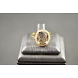 An 18ct gold ring with multi-faceted smoky quartz surrounded by diamonds, size M. CONDITION REPORT